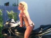 Busty blonde teases on a motorcycle in nylon 2/16