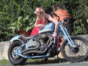 Cute blonde enjoys posing next to a bike 6/16