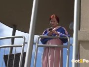 Redhead pees over her balcony in the city 1/16